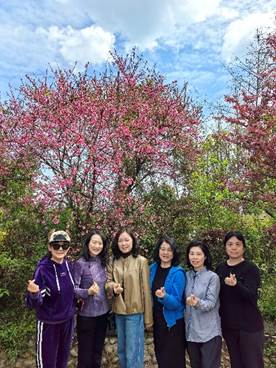 一群人站在树前合照 描述已自动生成